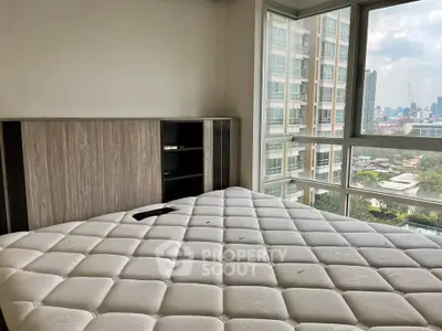 Spacious bedroom with large windows offering stunning city views in modern high-rise apartment.