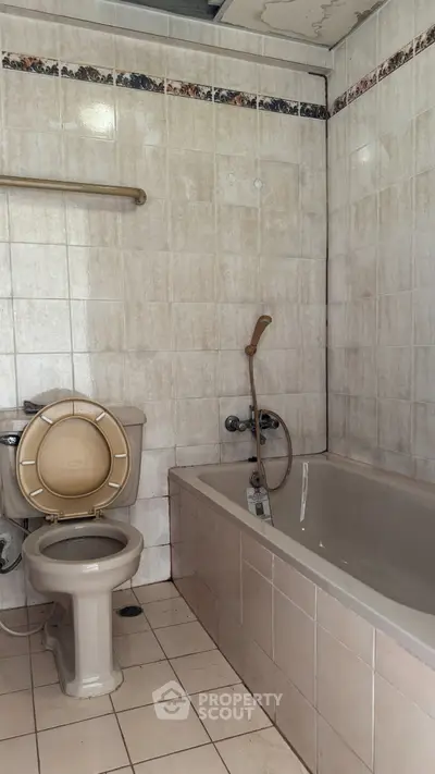 Spacious bathroom with bathtub and tiled walls, ideal for relaxation and comfort.
