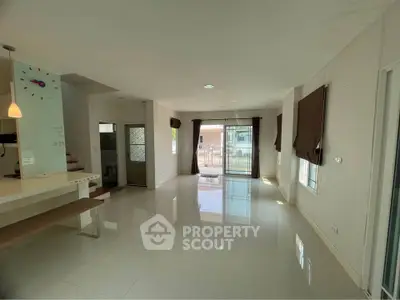 Spacious modern living room with large windows and sleek tile flooring