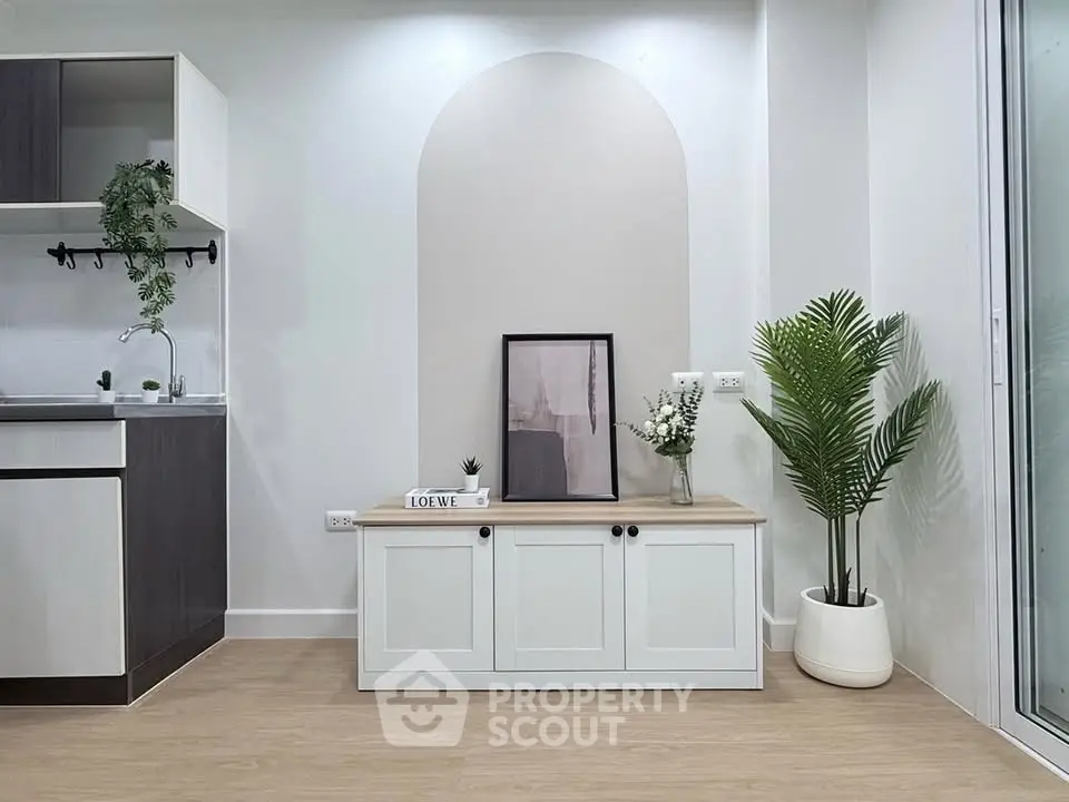 Modern minimalist living room with stylish decor and sleek kitchen area