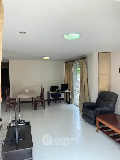 Spacious living room with modern furniture and natural light, perfect for relaxation and entertainment.