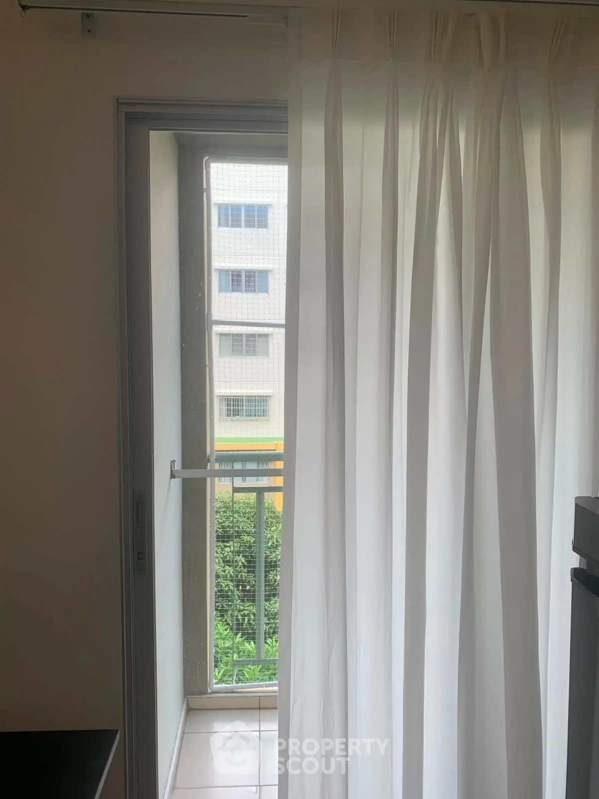 Bright room with sheer curtains and balcony view in modern apartment