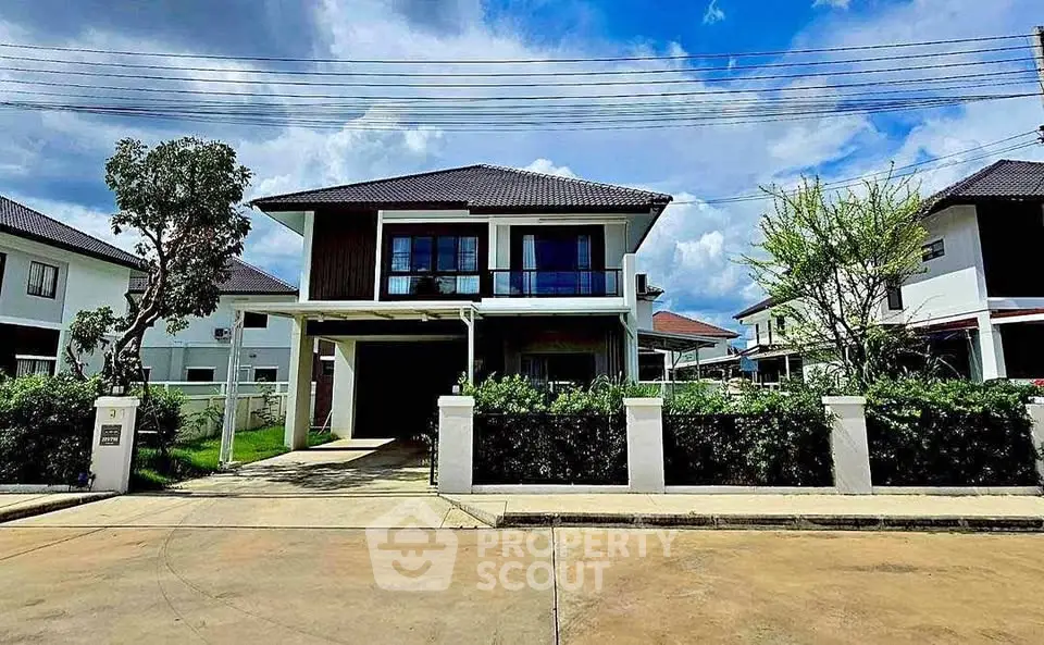 Modern two-story house with driveway and lush greenery in a suburban neighborhood.