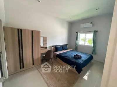 Spacious bedroom with modern furnishings and natural light, featuring a cozy bed and stylish wardrobe.