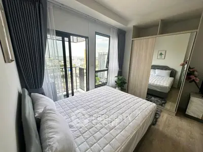 Modern bedroom with balcony view in high-rise apartment, featuring sleek design and ample natural light.