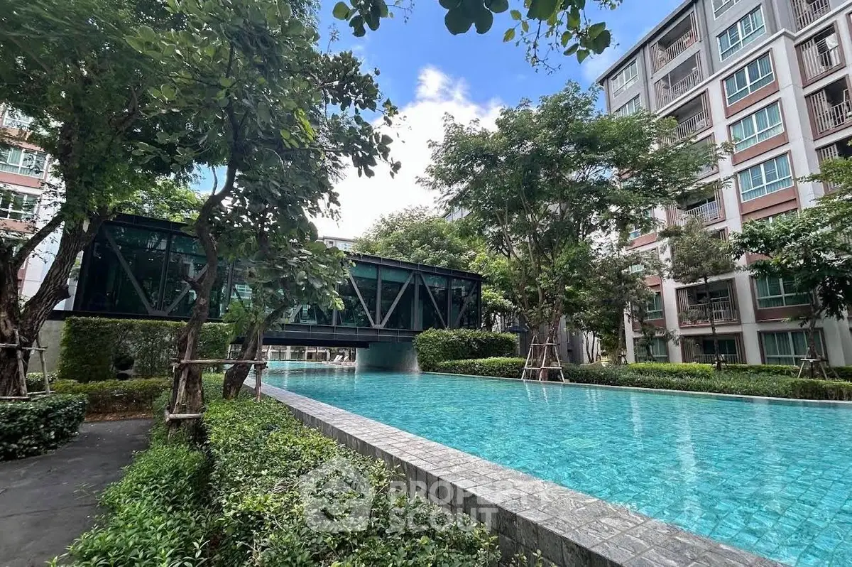 Luxurious condominium with stunning pool and lush greenery, perfect for relaxation and modern living.