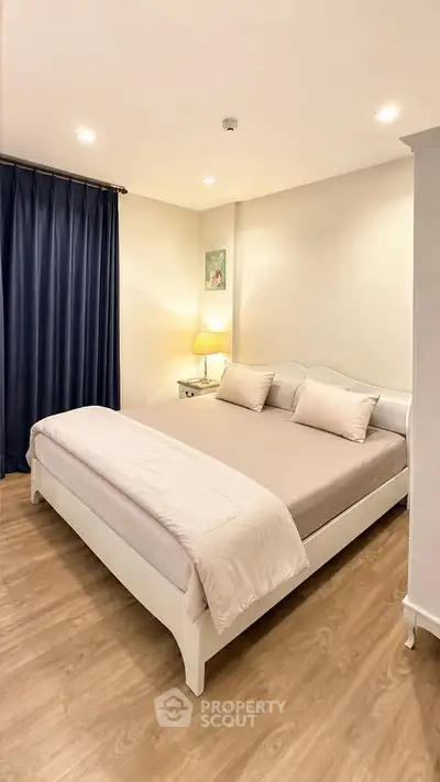 Cozy bedroom with elegant decor and soft lighting, featuring a comfortable bed and stylish curtains.