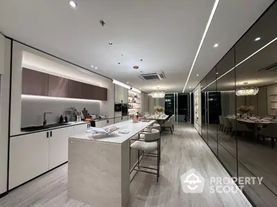 Luxurious modern kitchen with sleek design and open layout, featuring elegant lighting and spacious island.