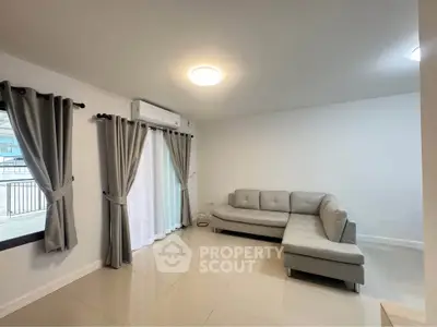 Spacious living room with modern gray sofa and large windows for natural light.