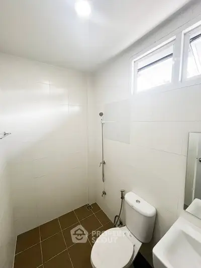 Modern minimalist bathroom with white tiles and natural light