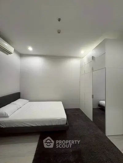 Modern minimalist bedroom with sleek design and ample storage space.