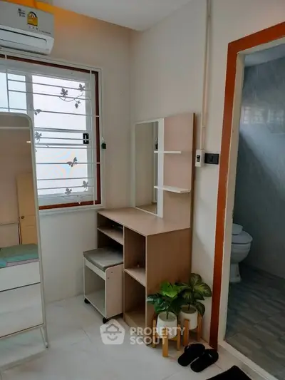 Cozy bedroom corner with vanity and bathroom view, perfect for modern living.