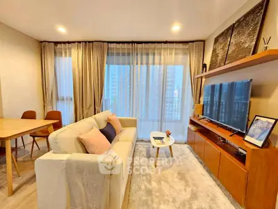 Modern living room with cozy sofa, large TV, and elegant decor in a high-rise apartment.