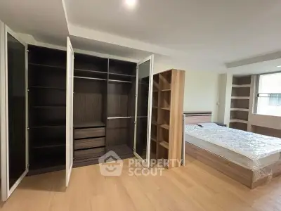Spacious bedroom with modern wardrobe and natural light in a stylish apartment.