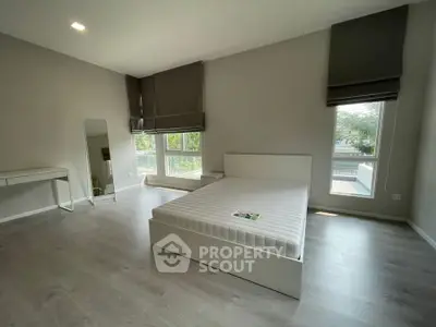 Spacious modern bedroom with large windows and minimalist decor