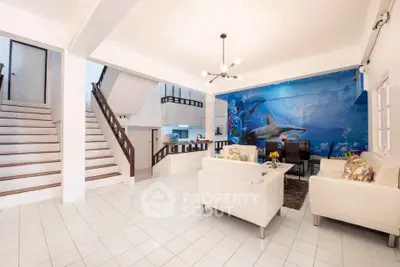 Spacious living room with ocean-themed mural and modern white furniture
