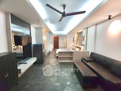 Spacious modern living room with sleek design and ceiling fan, featuring a cozy seating area and stylish decor.