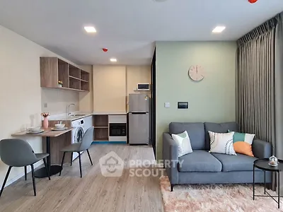 Modern open-plan living room with kitchen, featuring cozy sofa and dining area.