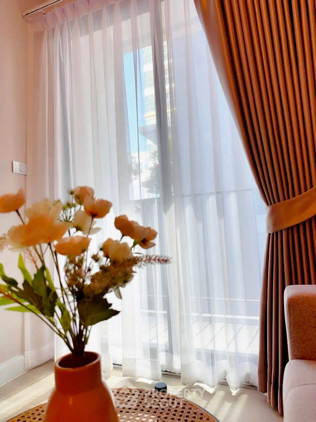 Bright living room with elegant curtains and a cozy seating area, perfect for relaxation.