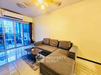 Spacious living room with modern gray sectional sofa and balcony access