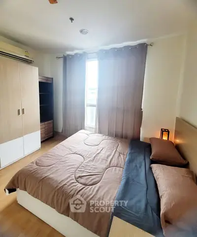 Cozy bedroom with modern furnishings and natural light in a stylish apartment.