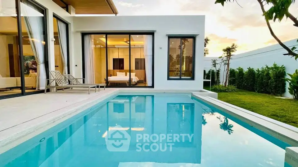 Luxurious modern villa with private pool and garden view at sunset.