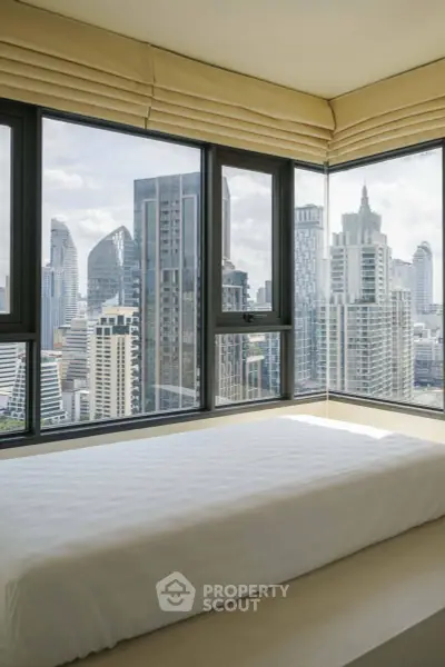 Stunning city view from modern bedroom with large windows and sleek design.