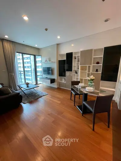 Modern living room with wooden flooring and large windows in a high-rise apartment