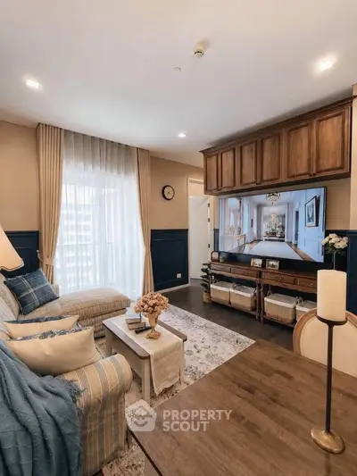Elegant living room with cozy seating, stylish decor, and large window for natural light.