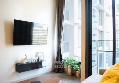 Modern living room with large window and wall-mounted TV in urban apartment
