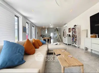 Spacious modern living room with cozy seating and open layout, perfect for relaxation and entertainment.