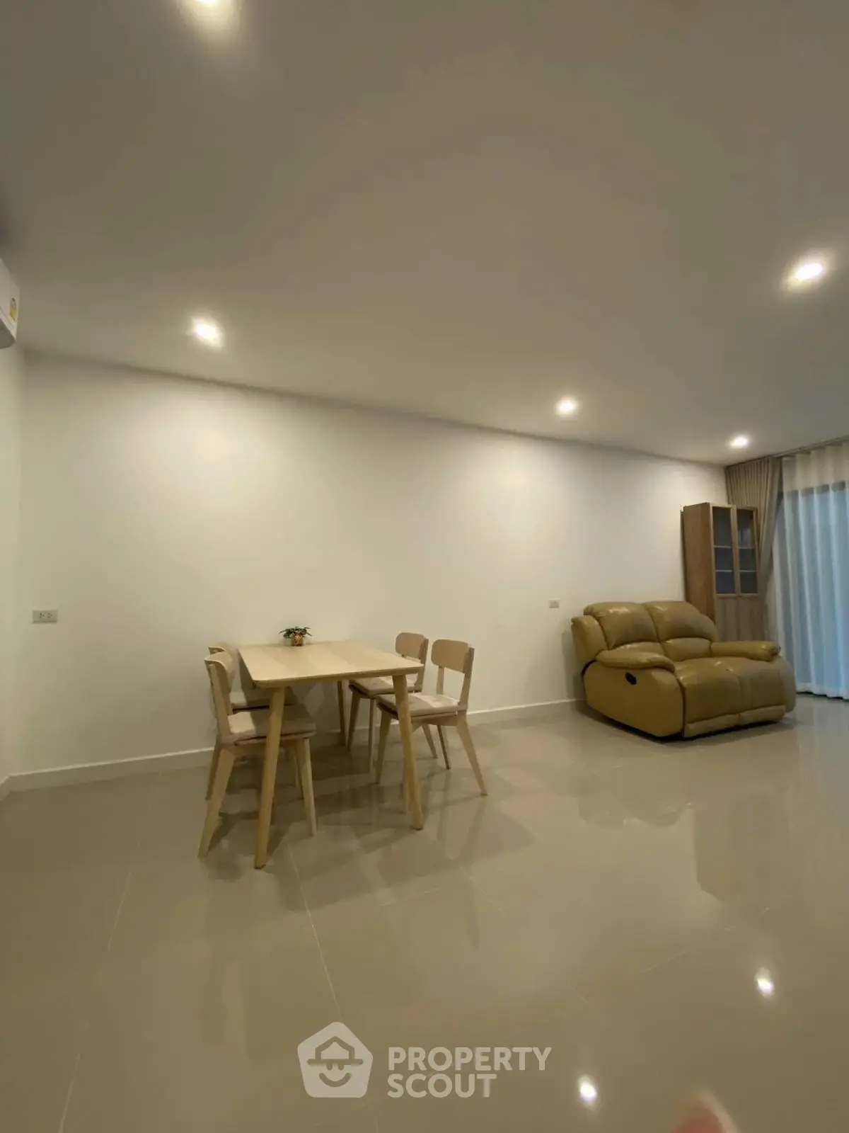 Spacious living room with modern furniture and elegant lighting, perfect for relaxation and entertainment.