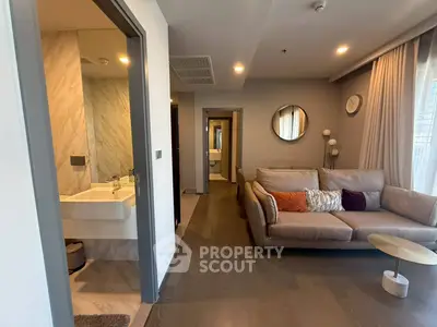 Modern living room with cozy sofa and adjacent bathroom in stylish apartment