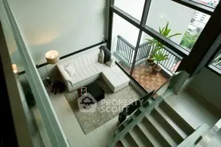 Modern loft-style living room with large windows and balcony view.