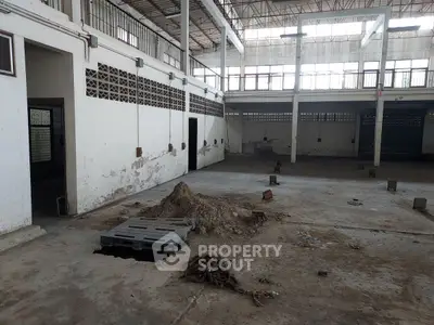 Spacious industrial warehouse with high ceilings and ample natural light.