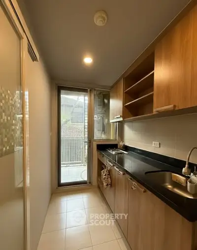 Modern kitchen with sleek cabinetry and balcony access