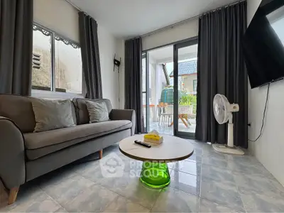 Cozy living room with modern sofa, stylish coffee table, and balcony access in a contemporary apartment.