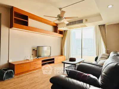 Spacious living room with modern furnishings and city view, featuring a ceiling fan and entertainment center.
