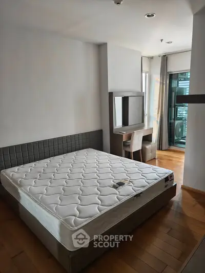 Modern bedroom with balcony access and stylish furniture in a contemporary apartment.
