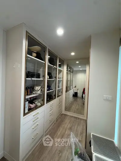 Spacious walk-in closet with elegant cabinetry and ample storage space.