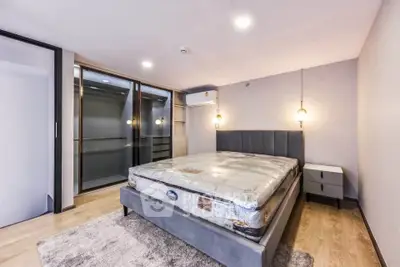 Modern bedroom with stylish lighting and spacious walk-in closet in a luxury apartment.