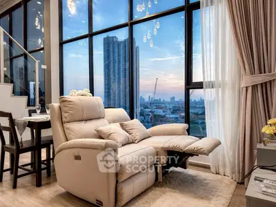 Luxurious living room with reclining sofa and stunning city view through floor-to-ceiling windows.