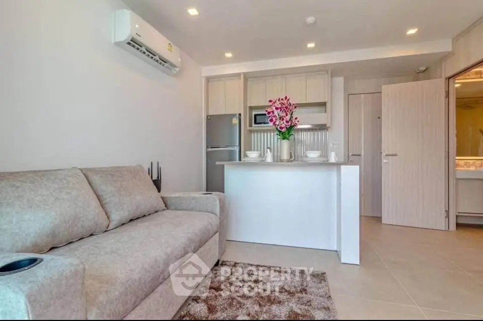 Modern open-plan living room with cozy sofa and stylish kitchen area.