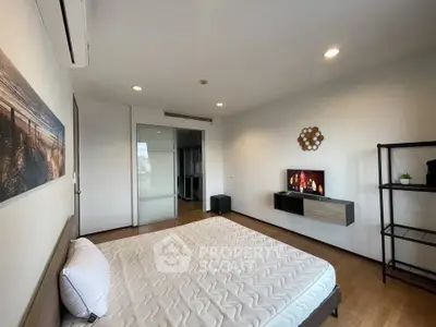 Spacious modern bedroom with stylish decor and ample natural light.