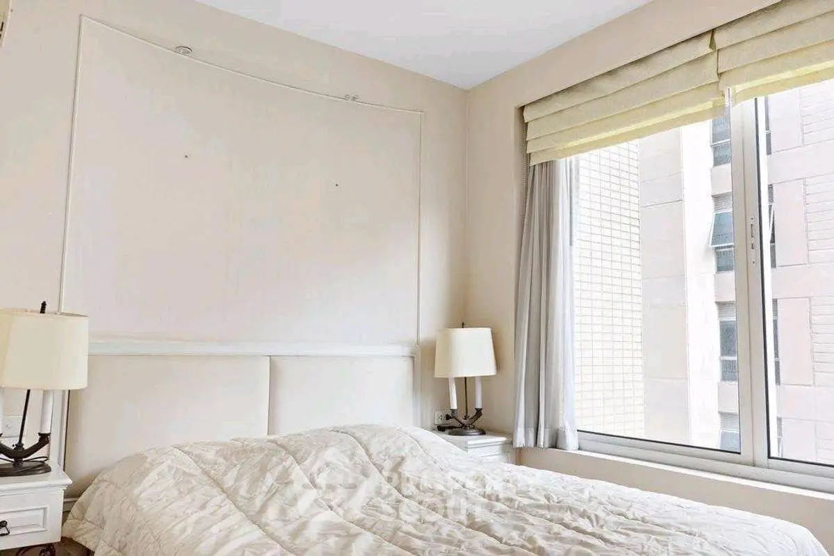 Bright and cozy bedroom with large window and elegant decor.