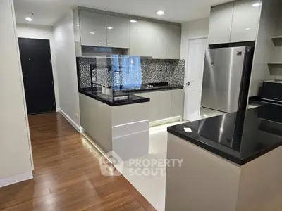 Modern kitchen with sleek cabinetry, stainless steel appliances, and elegant backsplash in a stylish apartment.