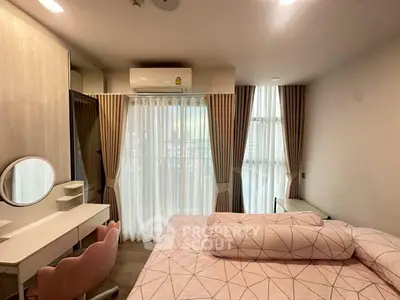 Cozy bedroom with modern decor, featuring a large window and stylish furnishings.