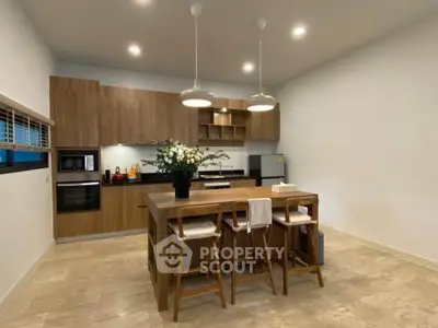 Modern kitchen with wooden cabinets and island in stylish apartment