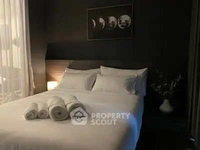Cozy bedroom with elegant dark decor and moon phase artwork, perfect for relaxation.