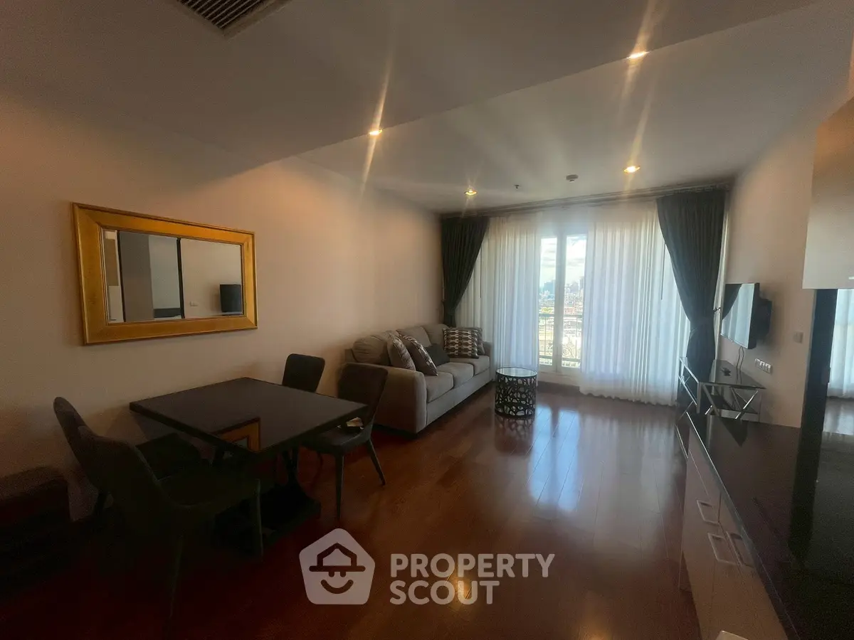 Spacious living room with elegant decor and large window offering natural light and city view.